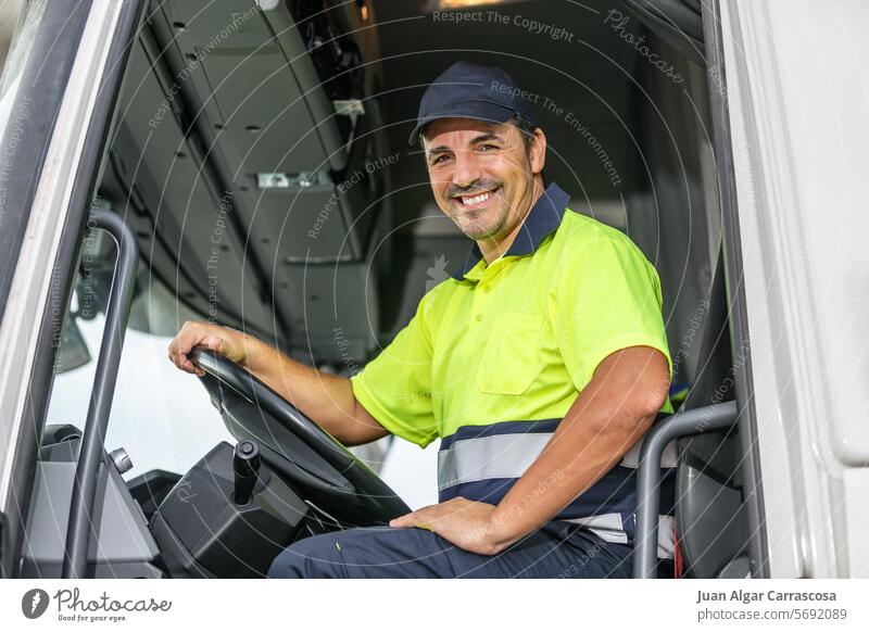 Gut gelaunter männlicher Fahrer, der in einem Lastwagen sitzt und in die Kamera schaut Mann Lächeln positiv Uniform Glück Fahrzeug Auto froh Verschlussdeckel