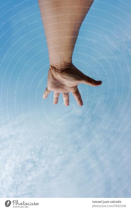 Mann gestikuliert mit der Hand in den blauen Himmel Arme Finger Haut Handfläche Körperteil hochreichen Hand erhoben Arm angehoben Blauer Himmel berührend Gefühl