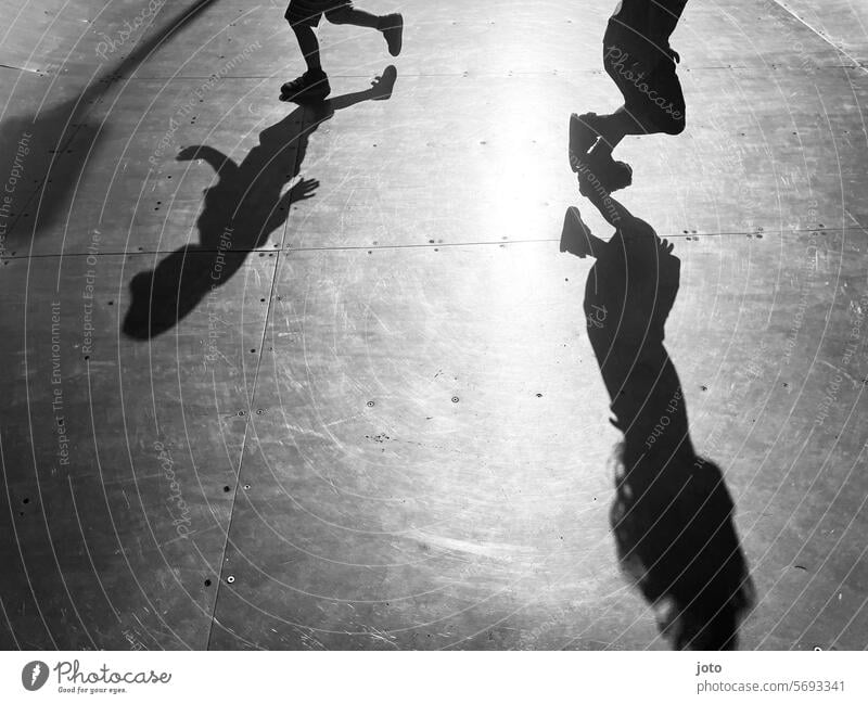 Silhouetten von Kindern rennen spielend auf einer Skaterbahn hin und her Silhouette Menschen Silhouettenfotografie Schatten Schattenspiel Schattenwurf