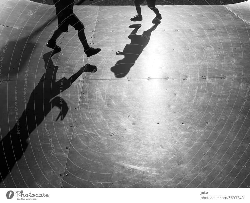 Silhouetten von Kindern rennen spielend auf einer Skaterbahn hin und her Silhouette Menschen Silhouettenfotografie Schatten Schattenspiel Schattenwurf