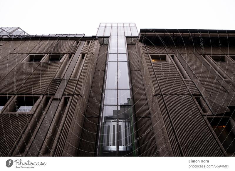 Imposante Gebäudefassade mit zentralem Aufzug aus Glas Fassade Bauwerk Struktur imposant groß Strukturen & Formen Glasaufzug gläsern Elemente Gegensätze stabil