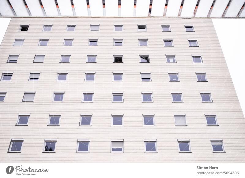 Koordinatensystem aus Fenstern in einer bildfüllenden Fassade eines Plattenbaus Hochhaus seriell Reihung Zeilen Spalten Wohnungen Wohnraum Anonymität