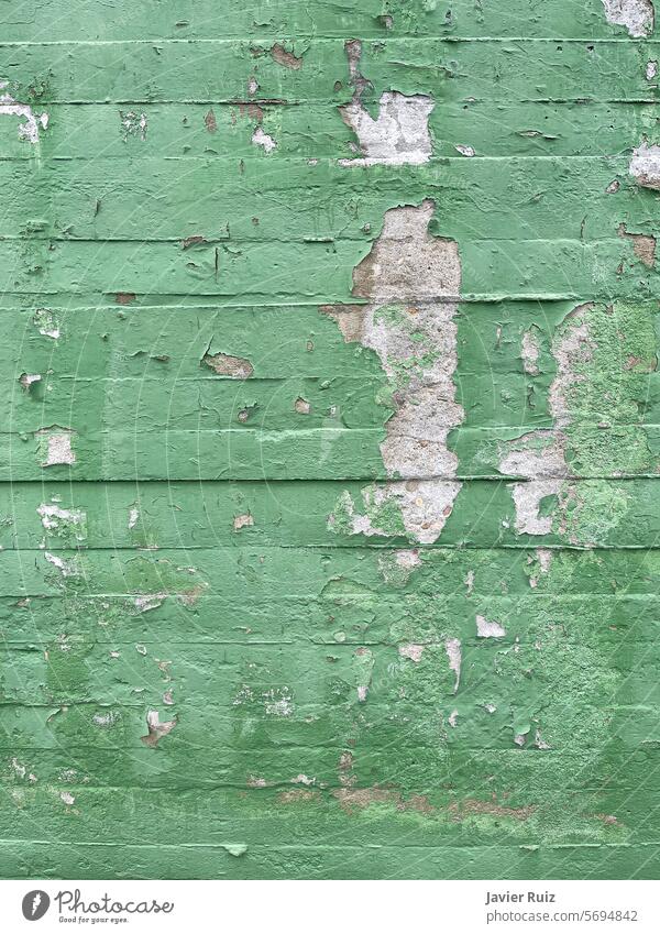 Textur einer grün gestrichenen Betonblockwand mit Farbfehlern und Abplatzungen, Zementwand in schlechtem Zustand Wand schlechter Zustand Absplitterung