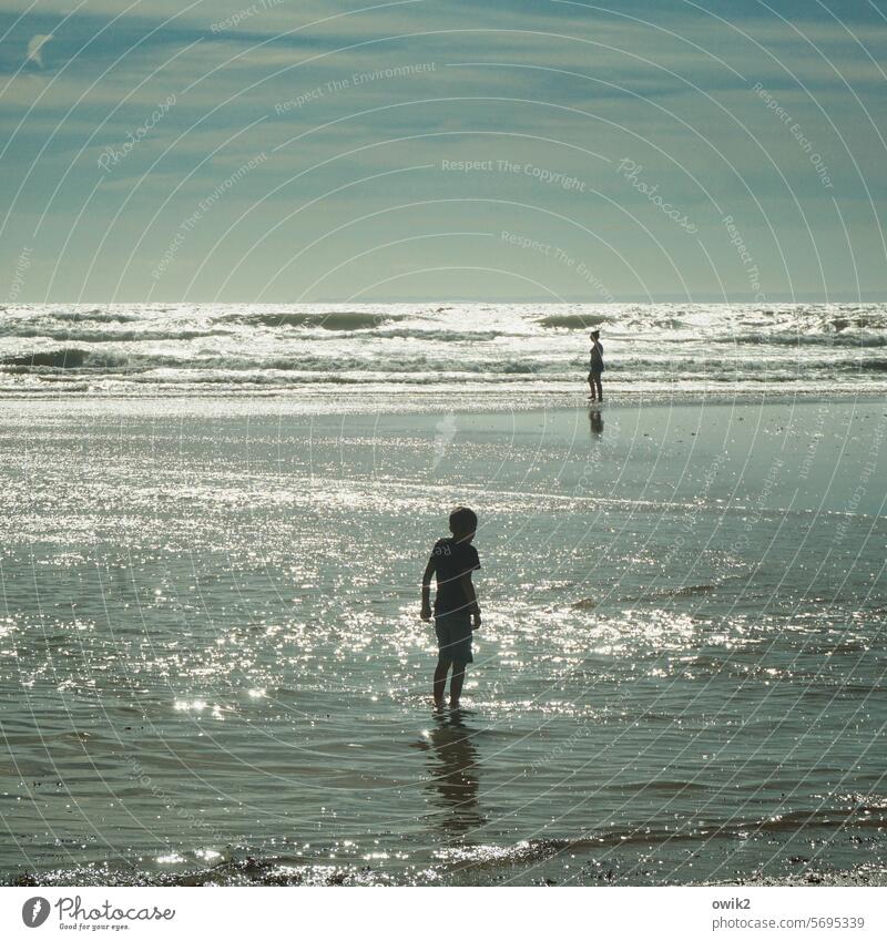 Flutung Meer Atlantik Wasser Gezeiten Wattwanderer zwei Silhouette Menschen Junge Frau stehen beobachten nasse füße Strand Küste Ferne Himmel Schleierwolken