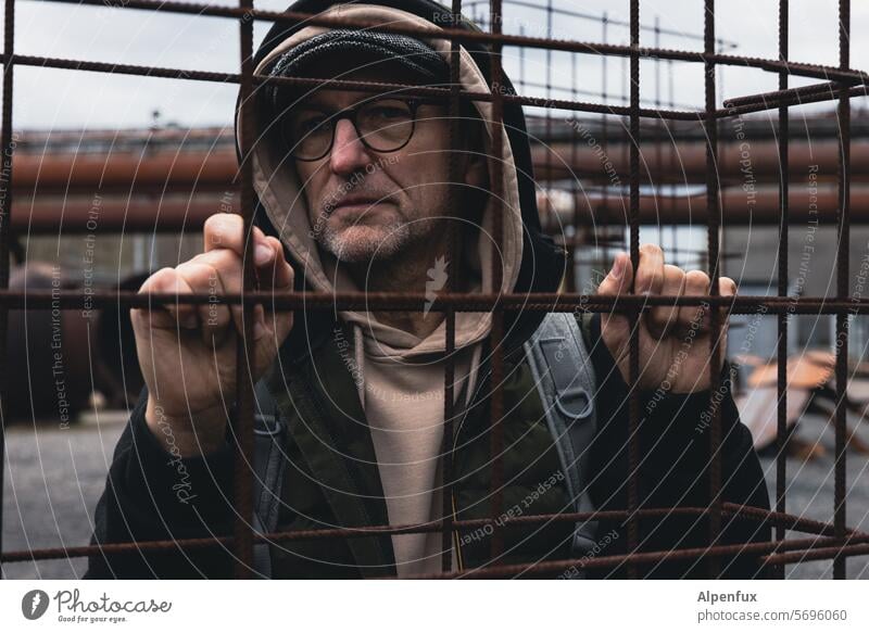 warm angezogener Mann hinter Gittern | Glückauf! eingesperrt Straflager gefangen Gefängnis Barriere Freiheit Grenze Gefangenschaft Schutz Sicherheit Zaun Angst