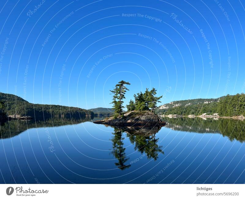 einsame Insel in kanadischem See insel see spiegelung blauer himmel freiheit ruhe stille einsame insel