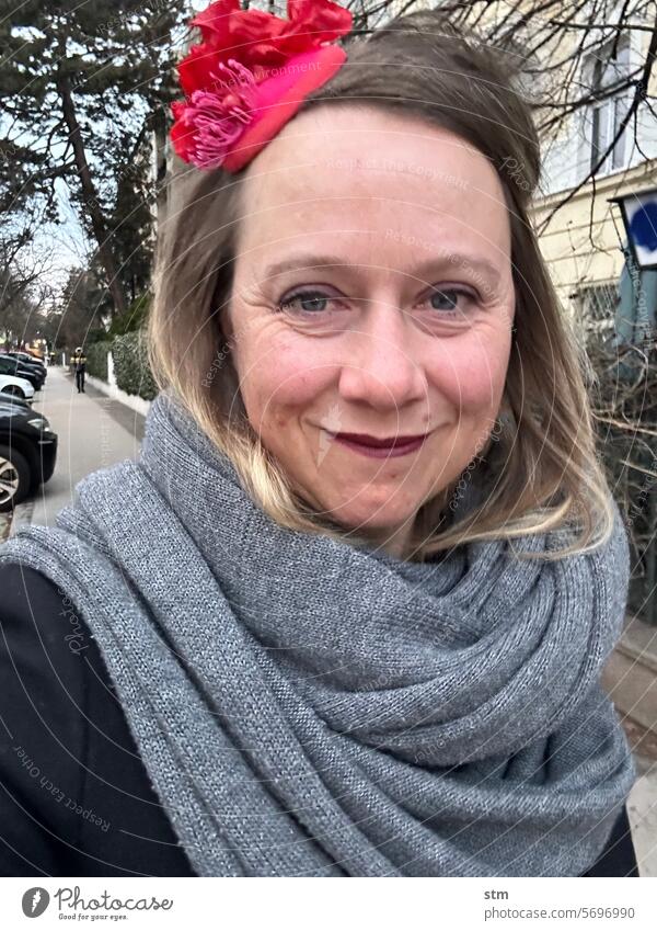 Frau mit rotem Hut Fascinator hütchen Porträt verschmitzt Lächeln Strasse Straße Gesicht Verschmitzt Blick in die Kamera Freundlichkeit feminin sympathisch Kopf