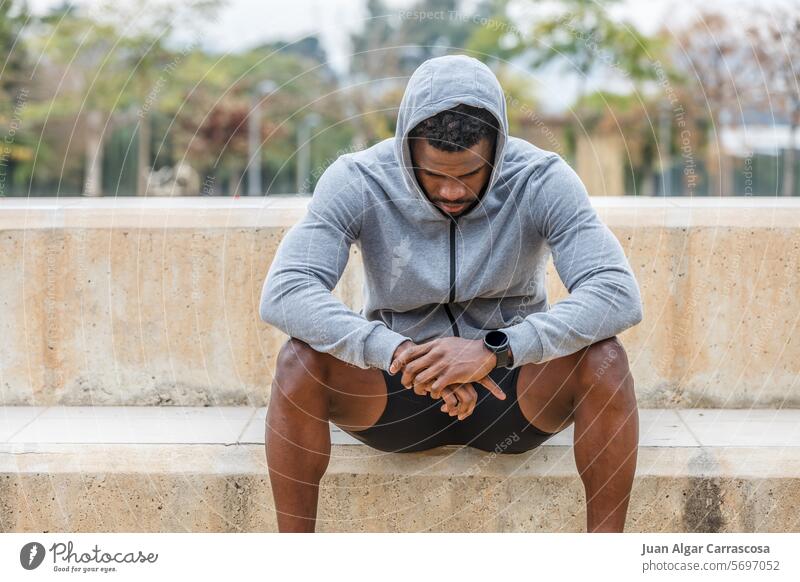 Trauriger schwarzer Sportler ruht sich nach dem Training aus Athlet Pause Melancholie drücken Versagen pausieren ruhen Treppe traurig verärgert müde Mann
