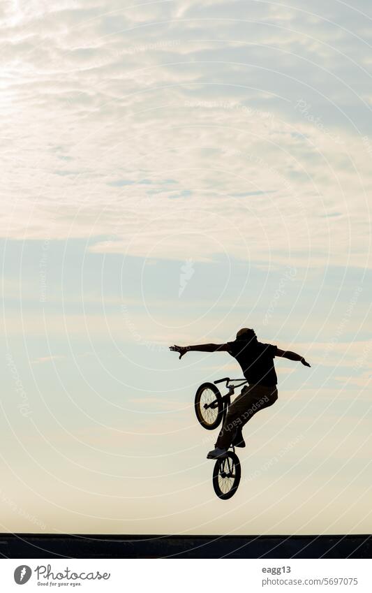 Freestyle-Radfahrer übt BMX auf der Straße Artist Adrenalin Athlet Gleichgewicht Fahrrad bmx Wolkenlandschaft Fahrradfahren Gefahr Tatkraft dramatischer Himmel