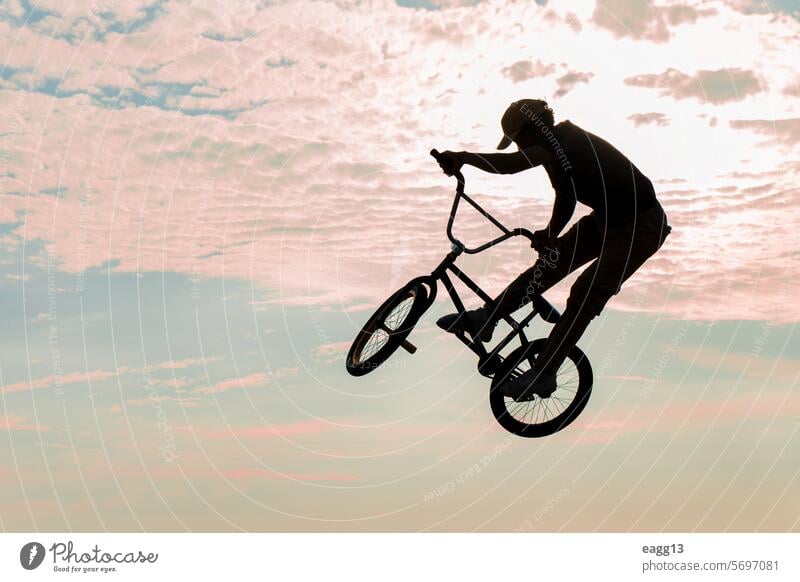 Freestyle-Radfahrer übt BMX auf der Straße Artist Adrenalin Athlet Gleichgewicht Fahrrad bmx Wolkenlandschaft Fahrradfahren Gefahr Tatkraft dramatischer Himmel
