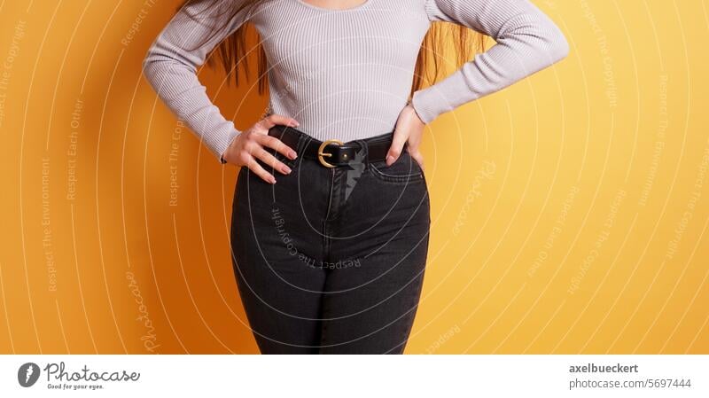 kurvige junge Frau mit weiblicher Figur oder Kurven, die enge schwarze Jeans trägt kurvenreich Jeanshose cameltoe Mode Form wohlgeformt hippe Körper Scheitel