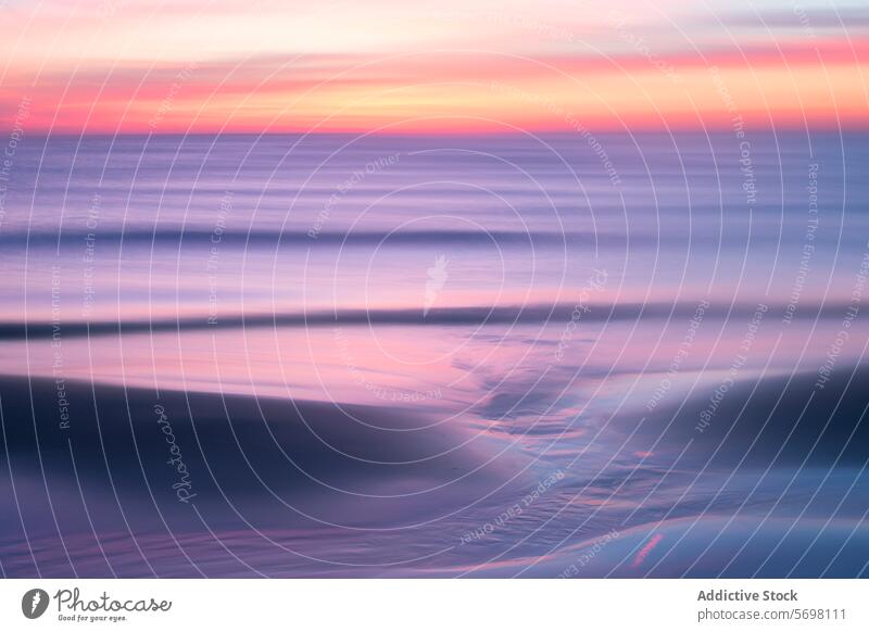 Ätherischer Sonnenuntergang in Pastellfarben über dem ruhigen Mittelmeer mit sanften Wellen und weichen Reflexionen auf dem Sand Windstille mediterran MEER