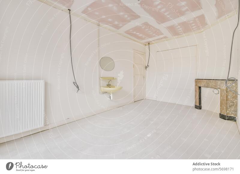 Unvollendeter leerer Raum mit freiliegender Decke und Waschbecken Renovierung Wand Zimmerdecke ausgesetzt Heizkörper Konstruktion unfertig Innenbereich