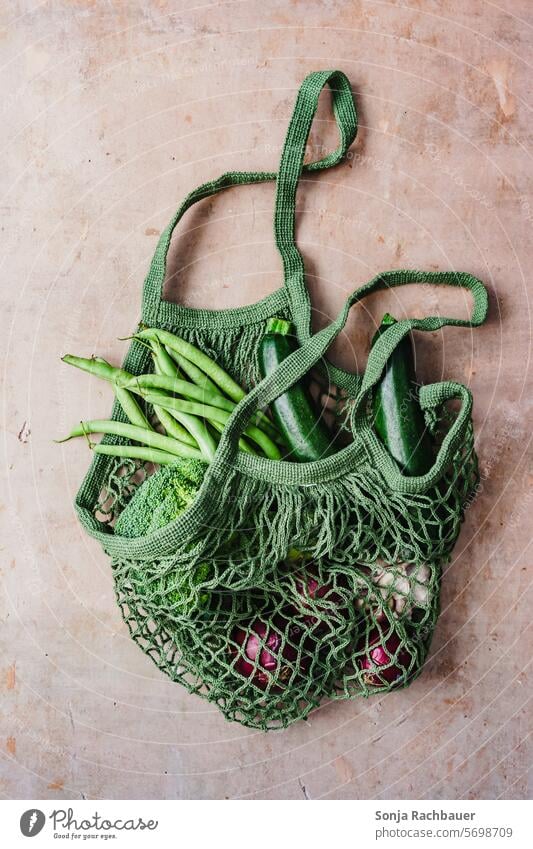 Eine grüne Netz Einkaufstasche mit frischen Gemüse Gesundheit organisch umweltfreundlich Tasche Veganer Lebensmittel wiederverwendbar Baumwolle Lifestyle Öko