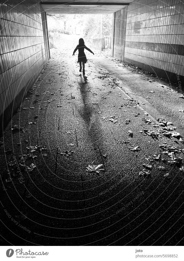 Silhouette von einem Kind rennt spielend durch einen Tunnel Silhouette Menschen Silhouettenfotografie Schattenspiel Schattenwurf Schattenbild Kinder rennen