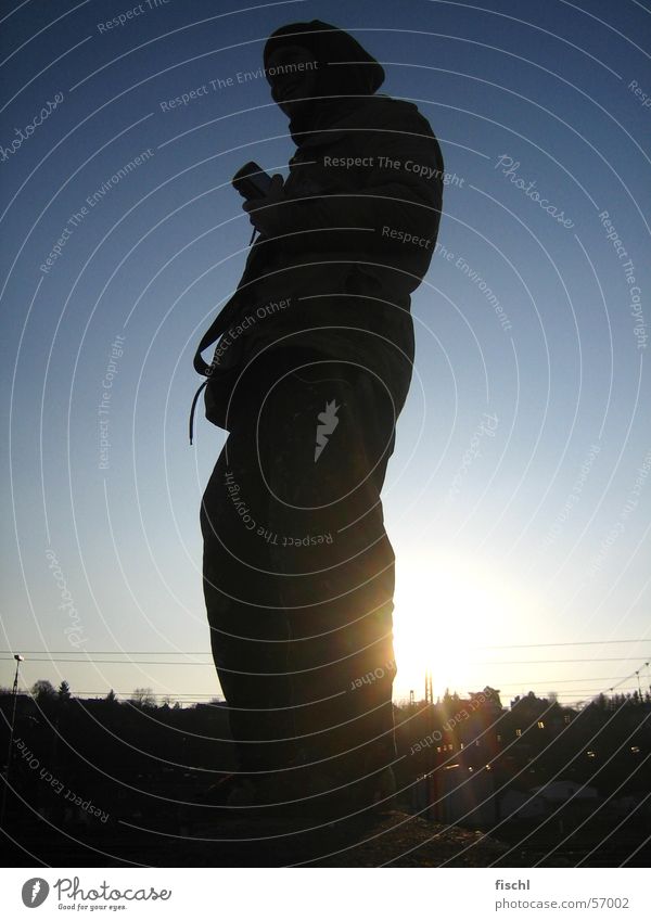 Sonntags Fotograf Spiegelreflexkamera Abendsonne Sonnenuntergang Silhouette Low Key Blende Suche finden kaputzenmensch warten