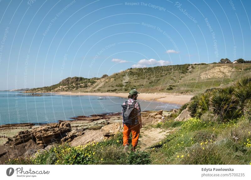 Mann beim Wandern entlang der Küste in Sizilien, Italien laufen wandern im Freien Fröhlichkeit Strand Menschen aktiv eine Person reisen Blick auf die Sichtweise