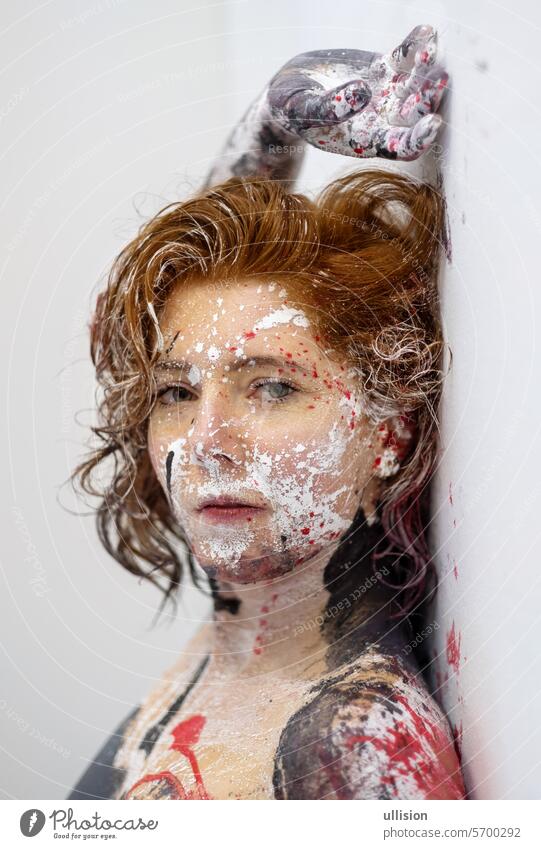Porträt einer sexy jungen brünetten nackten rothaarigen Frau, gemalte Punkte von roter, schwarzer und weißer Farbe, kreativer ausdrucksstarker abstrakter Körper, Gesichtsmalerei Kunst