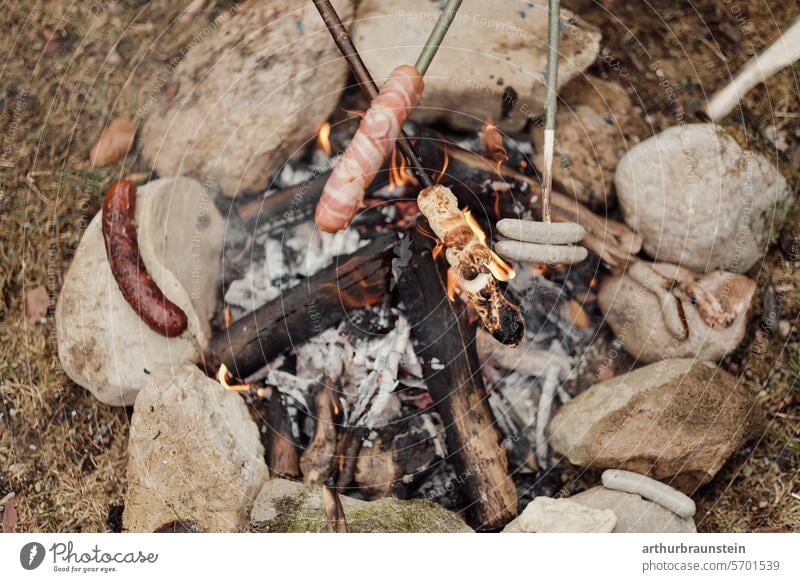 Grillen von Wurst und Brot über Lagerfeuer im Steinkreis in der Natur Lagerfeuerstimmung Steine Wiese Naturerlebnis Naturliebe Feuer Feuerstelle brennen