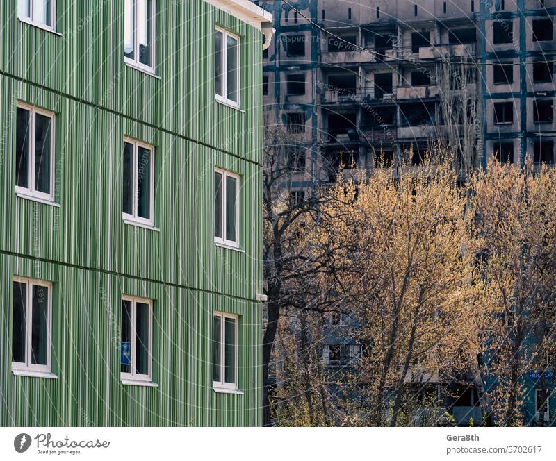 neu gebautes Haus vor dem Hintergrund der während der Kämpfe in der Ukraine zerstörten und verbrannten Häuser donezk Kherson kyiv Lugansk mariupol Russland