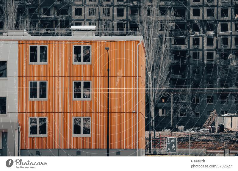 neue Häuser vor dem Hintergrund der verbrannten und zerstörten Häuser in der Ukraine donezk Kherson kyiv Lugansk mariupol Russland Saporoschje aussetzen