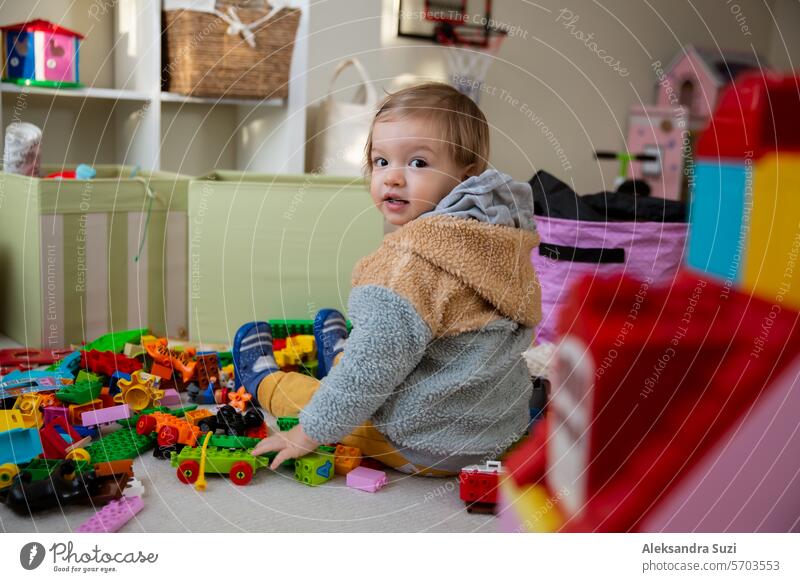Kleinkind spielt mit Spielzeug auf dem Boden zu Hause. Kinder lernen im Spiel. Häusliches Zimmer, Alltagsleben Aktivität bezaubernd Baby schön Blöcke bauen
