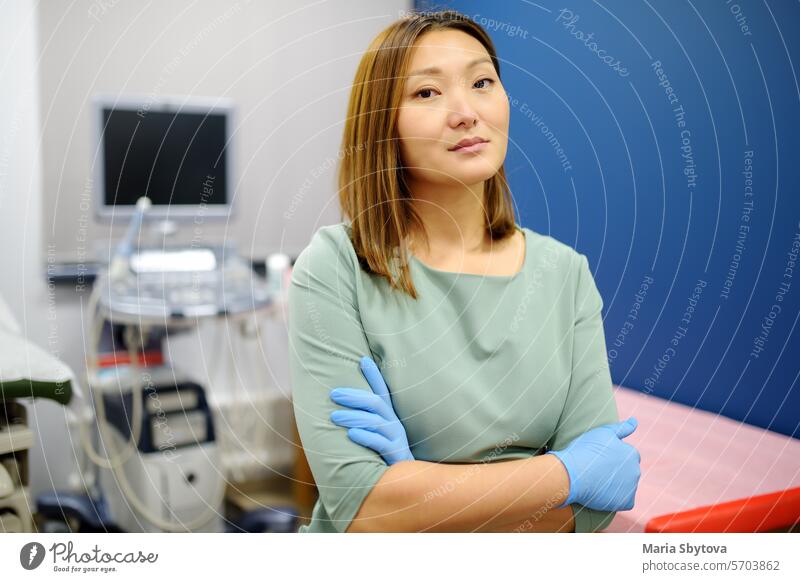 Porträt der asiatischen weiblichen Geburtshelferin Gynäkologe im Büro während der Arbeit. Professionelle und verantwortungsvolle Arzt arbeitet in einer modernen Klinik der Stadt