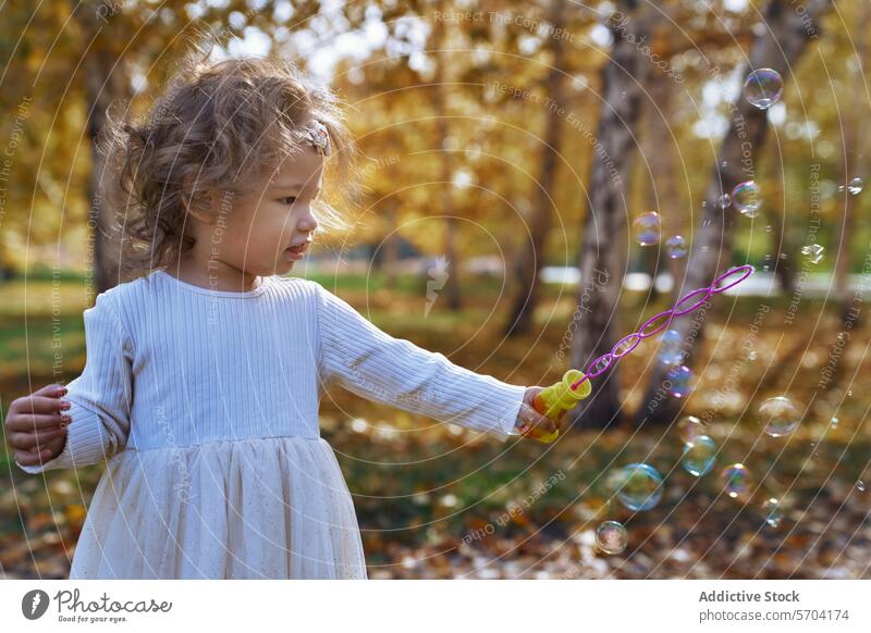 Ethnisches Kind spielt mit Seifenblasen in einem kalifornischen Park Blasen im Freien spielen Spaß Freude Kleinkind ethnisch Vielfalt Kalifornien Natur