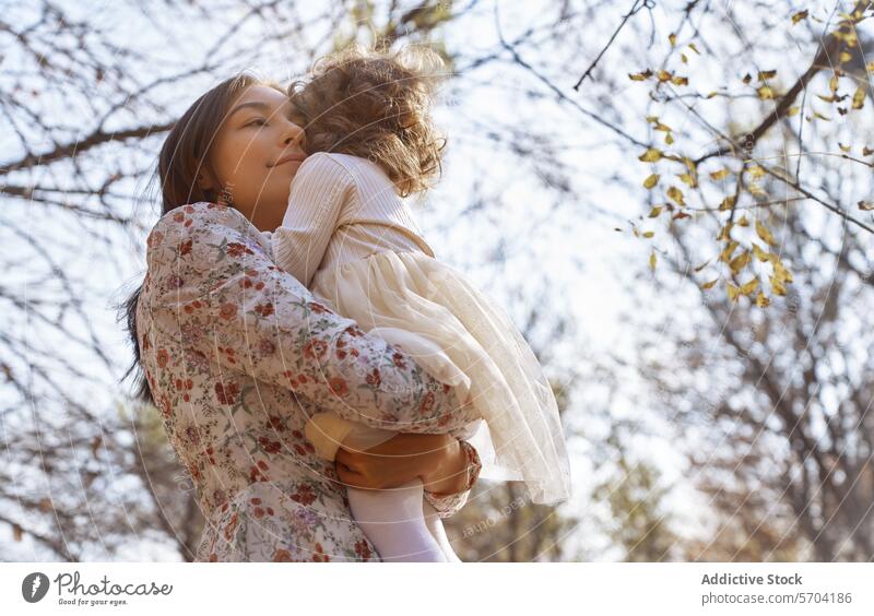 Ethnische Mutter und Kind umarmen sich im sonnigen Park Tochter ethnisch Umarmen Natur Kalifornien USA Bonden Liebe Familie im Freien Ruhe friedlich Zuneigung