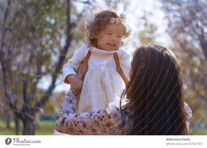 Anonyme Mutter und Tochter, die sich in einem sonnigen Park treffen Bonden Natur Kalifornien USA ethnisch genießen im Freien Bäume Fröhlichkeit Familie Liebe