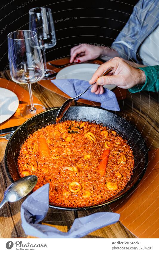 Genießen Sie eine traditionelle spanische Paella mit Meeresfrüchten Lebensmittel Pfanne Tisch speisend Wein Glas Person essen genießen Spanisch Küche Restaurant