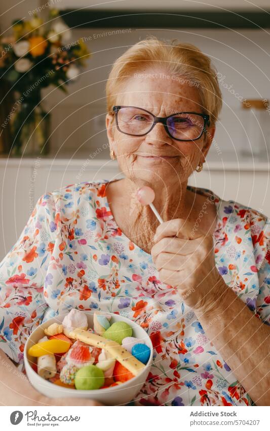 Ältere Frau genießt Süßigkeiten mit einem herzerwärmenden Lächeln älter Senior Lollipop Bonbon süß farbenfroh Brille heiter Fröhlichkeit Freude Dessert Snack
