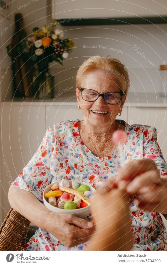 Ältere Frau, die lächelnd eine Obstschale erhält älter Lächeln Brille frisch Salatbeilage Küche gemütlich freudig Fröhlichkeit Senior Gesundheit Ernährung