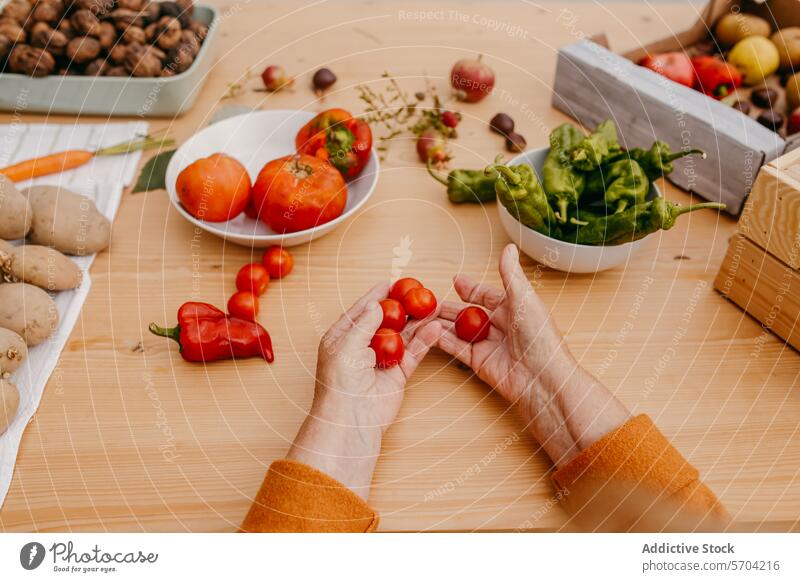 Gemüsezubereitung auf einem hölzernen Küchentisch Hände Kirschtomaten Holztisch Essensvorbereitung Gesundheit sortiert frisch Essen zubereiten