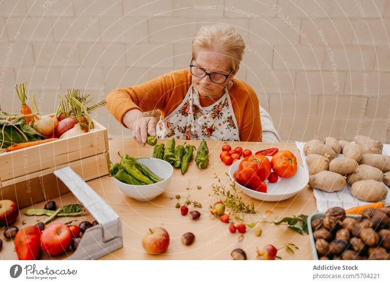 Ältere Frau bereitet frisches Gemüse in der Küche zu Senior Brille zerkleinernd Gesundheit produzieren Essen zubereiten Zubereitung von Speisen älter Ernährung