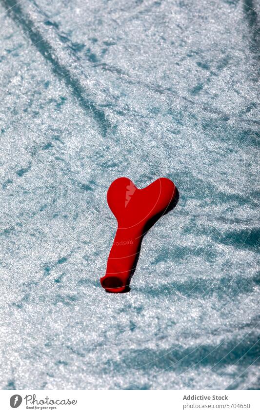 Rotes Herz geformt aufgeblasenen Ballon in floralem Stoff Hintergrund platziert Luftballon Liebe Dekor romantisch Anlass Aufschrift