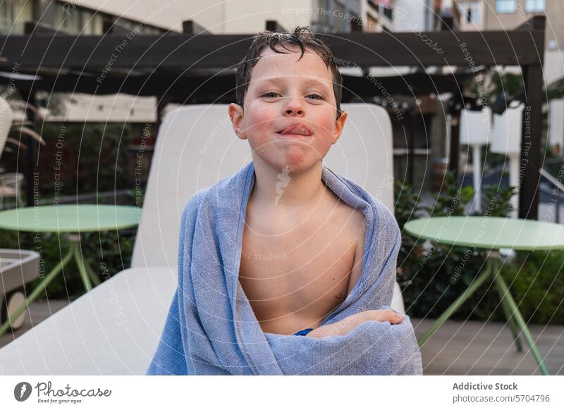 Junge, der nach dem Schwimmen in ein Handtuch eingewickelt ist und lächelt Kind schwimmen Pool Grinsen im Freien Freizeit Sommer tagsüber blau Genuss Spaß Glück