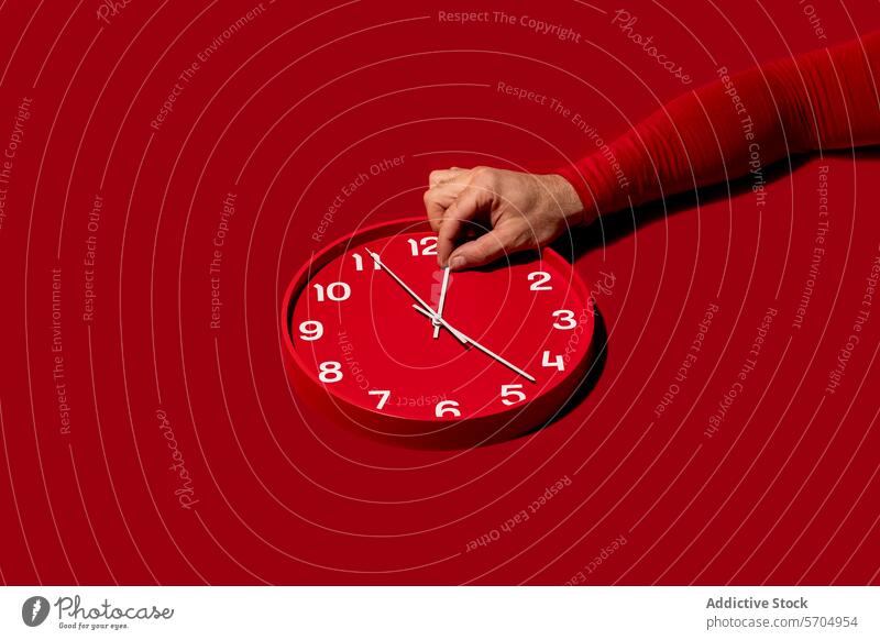 Einstellen der Uhrzeit an einer roten Wanduhr Hand Zeit Minute Stunde Hintergrund modern ausrichten Streichholz Kulisse Konzept Frist Wandel & Veränderung