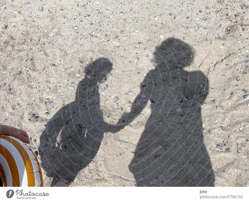 Mutter und Kind als Schatten auf dem Sand am Strand beim Baden Silhouette Mutterschaft mutter und kind zwei Menschen Hand halten Zusammensein Glück Kindheit