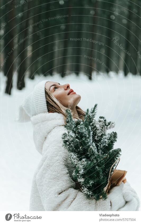 Glückliche junge Frau, die im Winterwald Schneeflocken mit dem Mund auffängt fangen Wald nachlässig Zunge Person Spaß Fell Mantel Moment emotional im Freien