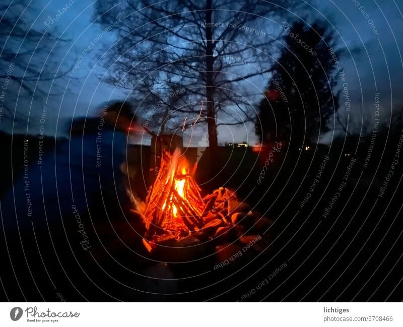 Fire-Laune. Lagerfeuer vor einem blauen Horizont und Baumsilhouette. kinder Romantik abends Stimmung spiel Bewegung Nacht