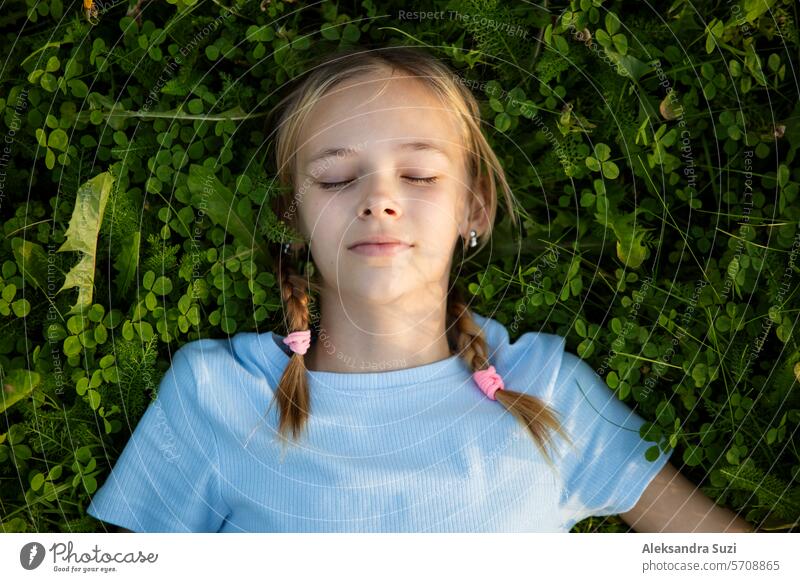 Porträt eines Mädchens im Teenageralter, das im Gras liegt. attraktiv schön Buch lässig Kind niedlich Bildung Genuss Frau Feld Freiheit grün Glück Wissen lernen