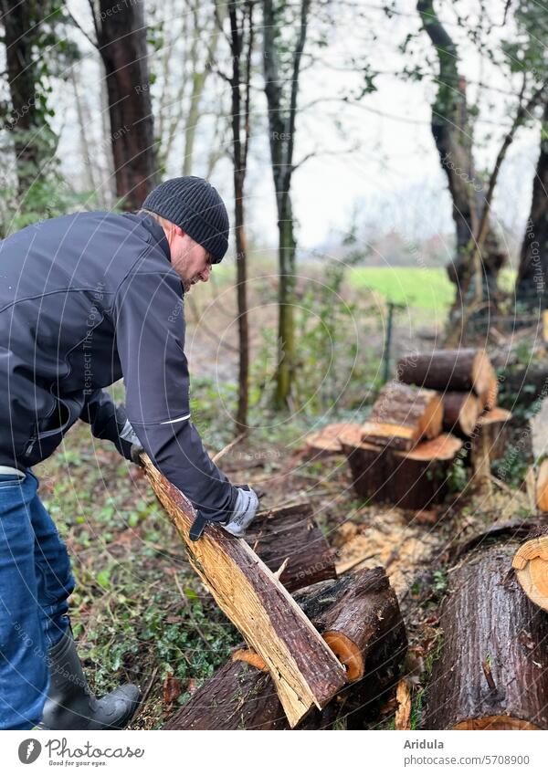 Ein Mann arbeitet im Garten | Baumfällen | Kleinholz Abholzung Nutzholz Stapel Jahresringe Baumscheibe geschnitten braun Struktur Rinde Baumrinde gestapelt Haus
