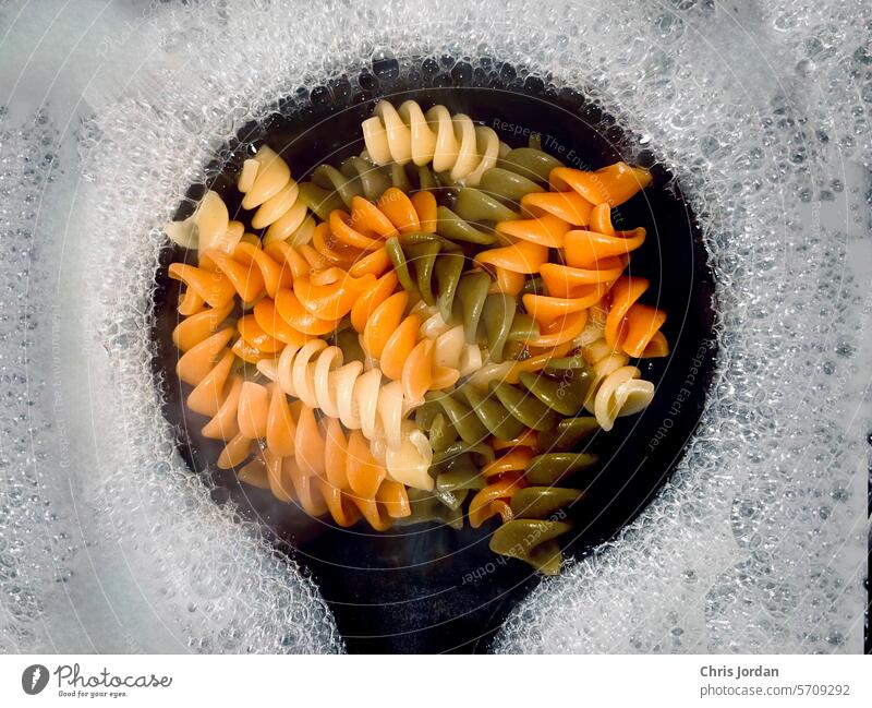 Dreifarbige Rotini Spätzle Wasser kochend Blasen Nahaufnahme Essen zubereiten Spirale Gesundheit