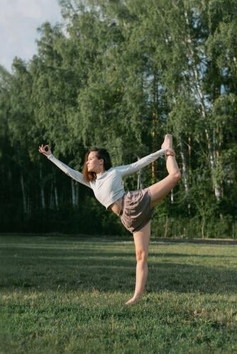 Erwachsene Frau übt draußen Yoga in Crop Top und Leinenhemd aktiv Körper Sommer Natur Training Sport strecken Kunstturnen Aerobic schlank Park Erholung physisch
