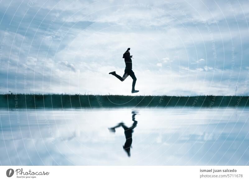 Mann springt und reflektiert auf dem See in der Landschaft Person eine Person springen springend Glück Fröhlichkeit genießen Freiheit Freude Spaß Urlaub Pfütze