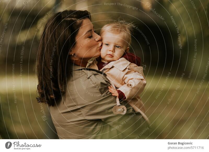 Junge Frau hält süßes Baby Mädchen im Herbst Park klein Kaukasier Mutter außerhalb Tochter Kind wenig Liebe niedlich Beteiligung Fröhlichkeit Zusammensein