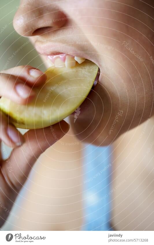 Crop Teenager-Mädchen beißen frische saftige Apfelscheibe zu Hause Biss Scheibe Gesundheit Vitamin Frucht Ernährung essen Lebensmittel lecker geschmackvoll süß
