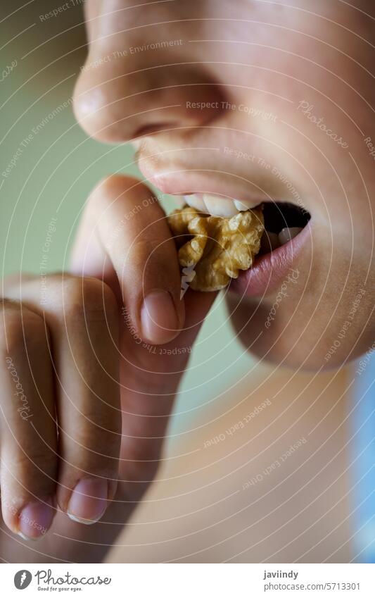 Anonymes Mädchen isst gesunden Walnusskern zu Hause Walnussholz Biss Gesundheit Nut hungrig Kernel frisch Diät Lebensmittel Snack Ernährung Protein Offener Mund