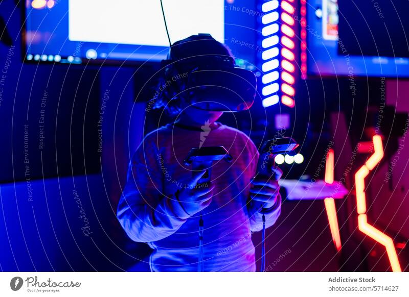 Anonymes Kind mit einem Virtual-Reality-Headset und Handheld-Controllern in einem Spiel in einer lebhaften Spielhalle mit Neonlicht Virtuelle Realität Regler